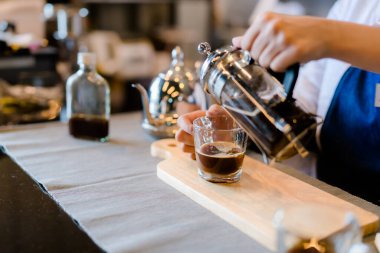 Profesyonel Asyalı kadın Barista, müşterilere kahve servisi yapıyor. Yarı zamanlı, yarı zamanlı, iş ya da iş kadını, içki satarken ve yaparken mutlu oluyor.