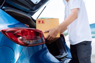 Karton kutu taşıyan teslimatçı, alıcıya taşıma sistemi hatchback otomobili ile göndermek için, müşteri evde çalışırken iş ürünü hizmeti için.