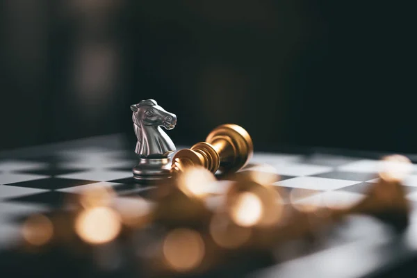 Gold and Silver Chess game knight winner staying on chessboard,Business planing strong concept with black background