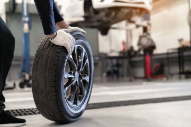Tamirci, tekerlek lastiği ve servis bakımını değiştirir. Araç süspansiyonu, güvenlik denetimi motoru. Müşteri uzun bir yolculuğa çıkmadan önce.