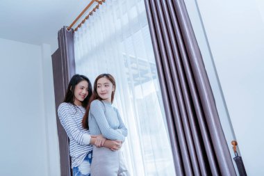 Aynı cinsiyetten Asyalı lezbiyen çift sabah yatak odasında kucaklaşır mutluluk hissi, LGBT kadın kucaklaşması evde birlikte yaşarlar.. 