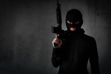 Soyguncu, hırsız ya da silahlı terörist saldırı için maskelenmiş siyah takım elbiseli, ateş etmeye hazır, arka plan şiddet kavramını kopyalamayı hedefliyor.