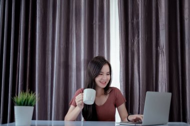 Bilgisayarlı Asyalı kadın risk azaltmak, karantina önleme koronavirüsü, covid-19 ve e-learing online eğitim teknolojisi kavramını öğrenmek için evden bilgisayarla kendini toplumdan soyutlamak için çalışıyor..