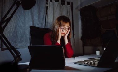 Gece geç saatlere kadar bilgisayar başında çalışan Asyalı kadın ekran monitörüne bakarak çok çalışıyor, Freelancer evde kalıyor uykusuz karantina krizi Coronavirüs karanlık odada..
