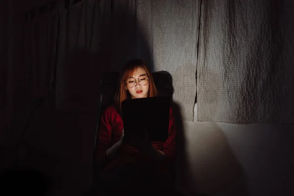 Asian woman working late at night with tablet digital gadget at home office work hard stressed serious emotion, Freelancer stay home business quarantine crisis coronavirus stay home dark room