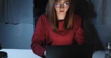 Asyalı kadın gece geç saatlere kadar bilgisayarlı ev bilgisayarlı ofiste çalışıyor. Ekran başında mutsuz görünüyor. Çok çalışıyor, Freelancer evde kalıyor..