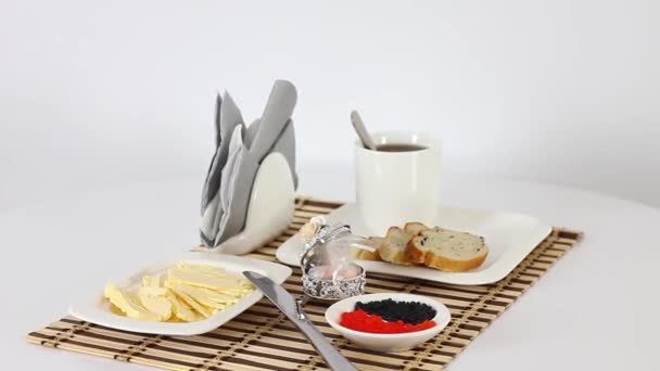 Tea cup with caviar and bread slices with butter on white spinning table background — Stock Footage Tea Cup Caviar Bread Slices Butter White Spinning Table Background Stock Video