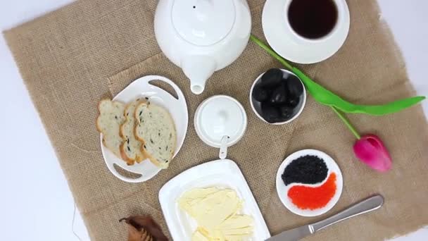 Top view spinning video of kettle with tea cup with bread slices and caviar with butter on table background — Stock Footage Top View Spinning Video Kettle Tea Cup Bread Slices Caviar Video Clip