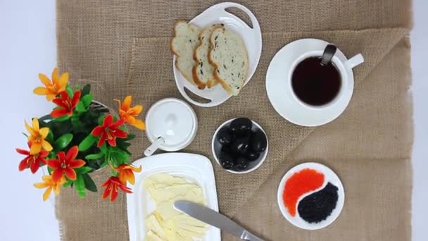 Top view spinning video of tea cup with bread slices and butter with caviar on table background — Stock Footage Top View Spinning Video Tea Cup Bread Slices Butter Caviar Stock Footage