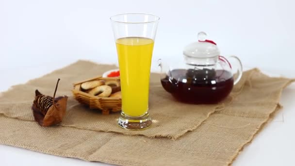 Juice glass with cookies in basket and tea kettle on spinning table background — Stock Footage Juice Glass Cookies Basket Tea Kettle Spinning Table Background Stock Video