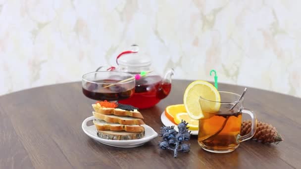 Teekocher mit schwarzem Tee und Meeresfrüchten Kaviar auf Tischhintergrund