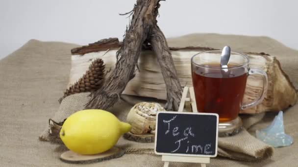 Teetasse mit Zitrone und getrockneten Baumstämmen auf Holztischhintergrund