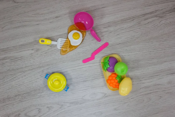 Plastic Kids toys collection on floor - utensil and cooking, food theme.