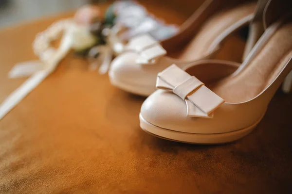 Hochzeitsaccessoire Braut. schicke beige Schuhe, Knopfloch und Strumpfband auf Holzgrund. — Stockfoto