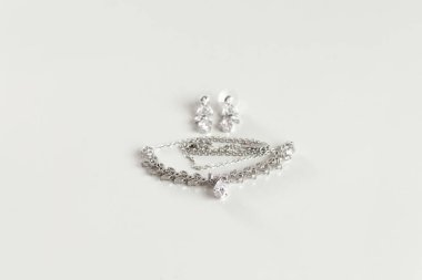 Gelin için aksesuarlar. Taklit Mücevherler - beyaz arka planda cilalanmış gümüş kolye. Mesaj, reklam yeri..