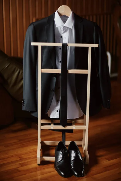 Preparativos para la boda. Chaqueta de novio en el soporte y corbata, zapatos cerca. Las reuniones del novio de la mañana en el día de la boda . —  Fotos de Stock