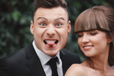 Eğlenceli ve çılgın gelinler. Mutlu muhteşem gelin ve şık damat zıplıyor ve eğleniyor, düğün çifti, lüks düğün.