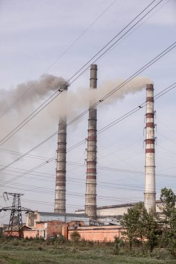 Enerji santrali insanlar için enerji üretiyor. Yüksek voltaj direği. Bacalardan gökyüzüne doğru duman çıkıyor. seçici odak