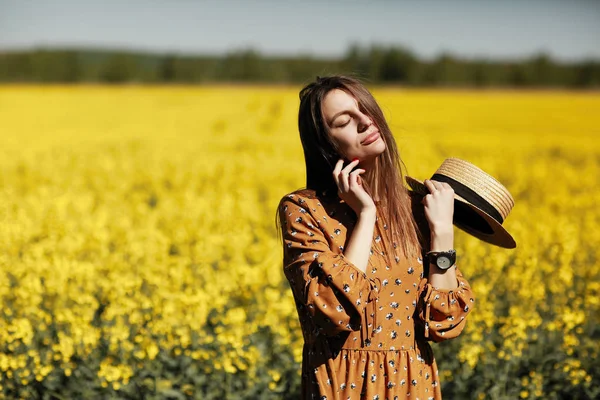 Sarı çiçek tarlasında genç bir kadının portresi. Yaz mutluluğu konsepti, güzel kız — Stok fotoğraf