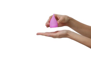 Pembe adet kupası. Beyaz arka planda regl bardağını tutan kadının yakın plan fotoğrafı. Kadın sağlığı konsepti, sıfır atık alternatif