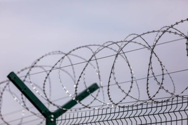 Gökyüzündeki dikenli teller arka plandaki dikenli teller. Metal tel. seçici odak