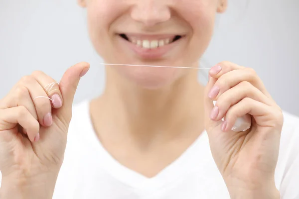 Dental hygiene and care. Dental floss. Young healthy woman face with beauty smile. Beautiful girl. Person healthcare. Female in the morning in bathroom. — Stock Photo, Image