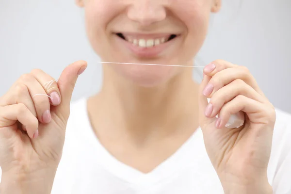 Higiene y cuidado dental. Hilo dental. Cara de mujer joven y saludable con sonrisa de belleza. Hermosa chica. Salud de la persona. Mujer por la mañana en el baño . — Foto de Stock