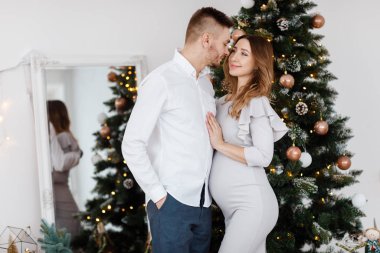 Noel 'de aşık olan şık, güzel ve hamile bir çift yeni yıldan önce Noel tatillerinde dinleniyor. Koca hamile göbek..