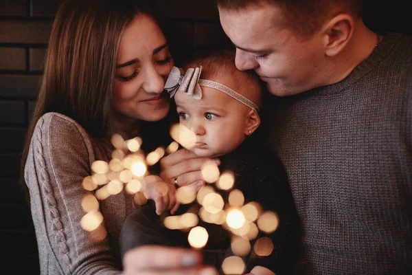 Retrato de família feliz, mãe, pai e bebê menina com faíscas na frente. família em antecipação do Natal. foto seletiva . — Fotografia de Stock