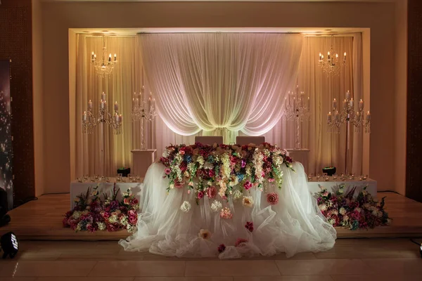Mesa festiva decorada com composição de flores brancas, vermelhas e rosa e vegetação no salão do banquete. Recém-casados de mesa na área do banquete na festa de casamento . — Fotografia de Stock