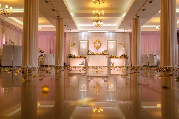 Mesa festiva decorada con composición de flores blancas, rojas y rosadas y vegetación en la sala de banquetes. Mesa recién casados en el área de banquete en la fiesta de boda . — Foto de Stock