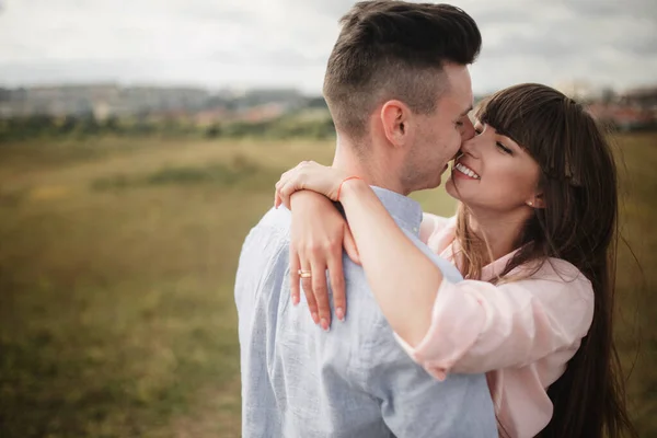 Loving ungt par kyssas och kramas i utomhus. Kärlek och ömhet, dating, romantik, familj, årsdagen koncept. — Stockfoto