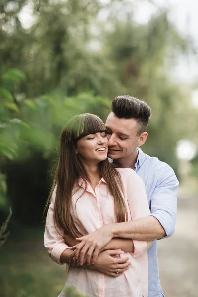 Loving ungt par kyssas och kramas i utomhus. Kärlek och ömhet, dating, romantik, familj, årsdagen koncept. — Stockfoto