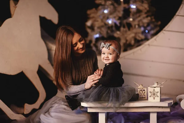 Glückliche Mutter mit ihrer kleinen Tochter haben eine gute Zeit zusammen zu Hause. Mutter mit Tochter inmitten der Weihnachtsdekoration — Stockfoto