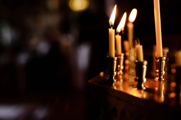 Queimando velas na igreja no fundo escuro — Fotografia de Stock