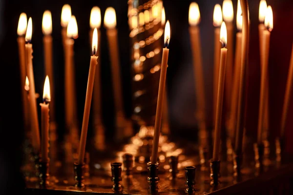 Burning candles in church on dark background — Stock Photo, Image