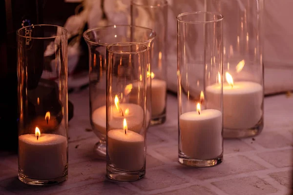 Gezellig decor met brandende kaarsen in glazen kolven — Stockfoto