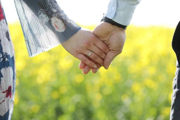 Couple amoureux se tiennent la main dans le champ vert en été. gros plan photo — Photo