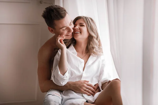 Casal amoroso se divertindo juntos em casa, esposa brincalhão mordendo sorridente marido orelha, piggyback, homem e mulher jogando infantil na cama, desfrutando de momentos íntimos engraçados — Fotografia de Stock