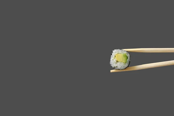 Verse vegetarische maki sushi roll met houten eetstokjes geïsoleerd op grijze achtergrond. kopieerruimte — Stockfoto