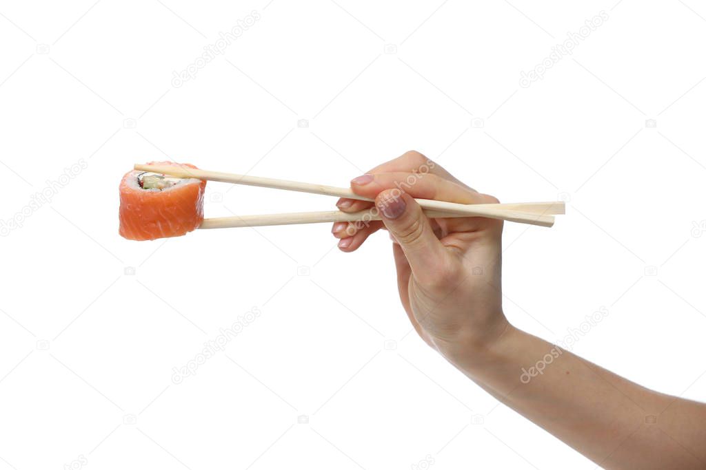 Woman hand holding fresh sushi roll with wooden chopsticks, isolated on white background