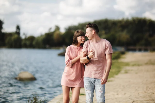 Unga romantiska par har kul på sommaren solig dag nära sjön. Njuter av att tillbringa tid tillsammans på semester. Man och kvinna kramas — Stockfoto