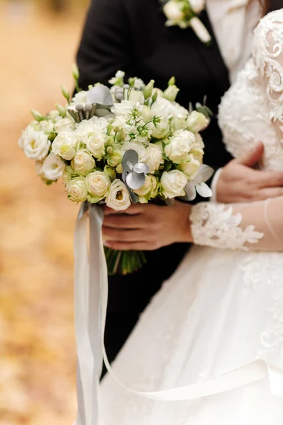 Día de la boda. Novia y novio tiene un ramo de flores rosas y blancas. Decoración de boda . — Foto de Stock