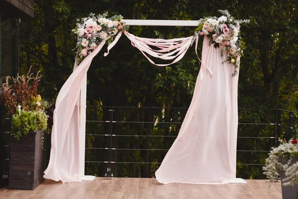 Decorazione nuziale con arco all'esterno con rose rosa e bianche e tessuto bianco — Foto Stock