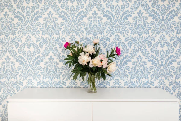 Peonies Fresh Cut Flores em vaso com espaço de cópia na tabela branca no fundo azul — Fotografia de Stock
