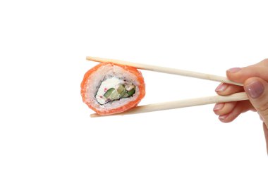 female hand holding sushi roll with chopsticks against pure white background.