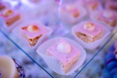 Candy bar on wedding ceremony with a lot of different cupcakes, modern desserts, mousses and jellies. selective focus