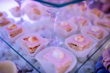 Candy bar on wedding ceremony with a lot of different cupcakes, modern desserts, mousses and jellies. selective focus