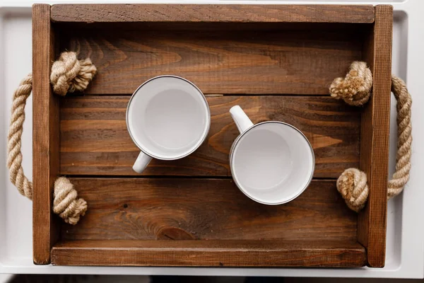 Top flat view of two white empty cups on rustic wooden tray and background. Cozy home, lovely breakfast with beloved — Stockfoto