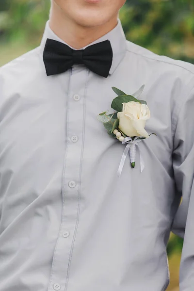 Rosas brancas flores na casa de botão, o amigo noivos está vestido com uma camisa cinza e um laço. Dia do casamento. Roupa do dia . — Fotografia de Stock